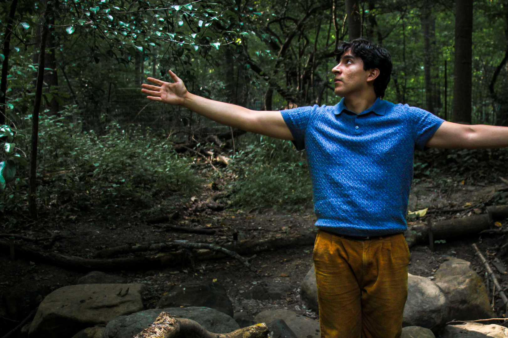 Chris Michael performing with arms outstretched in the woods