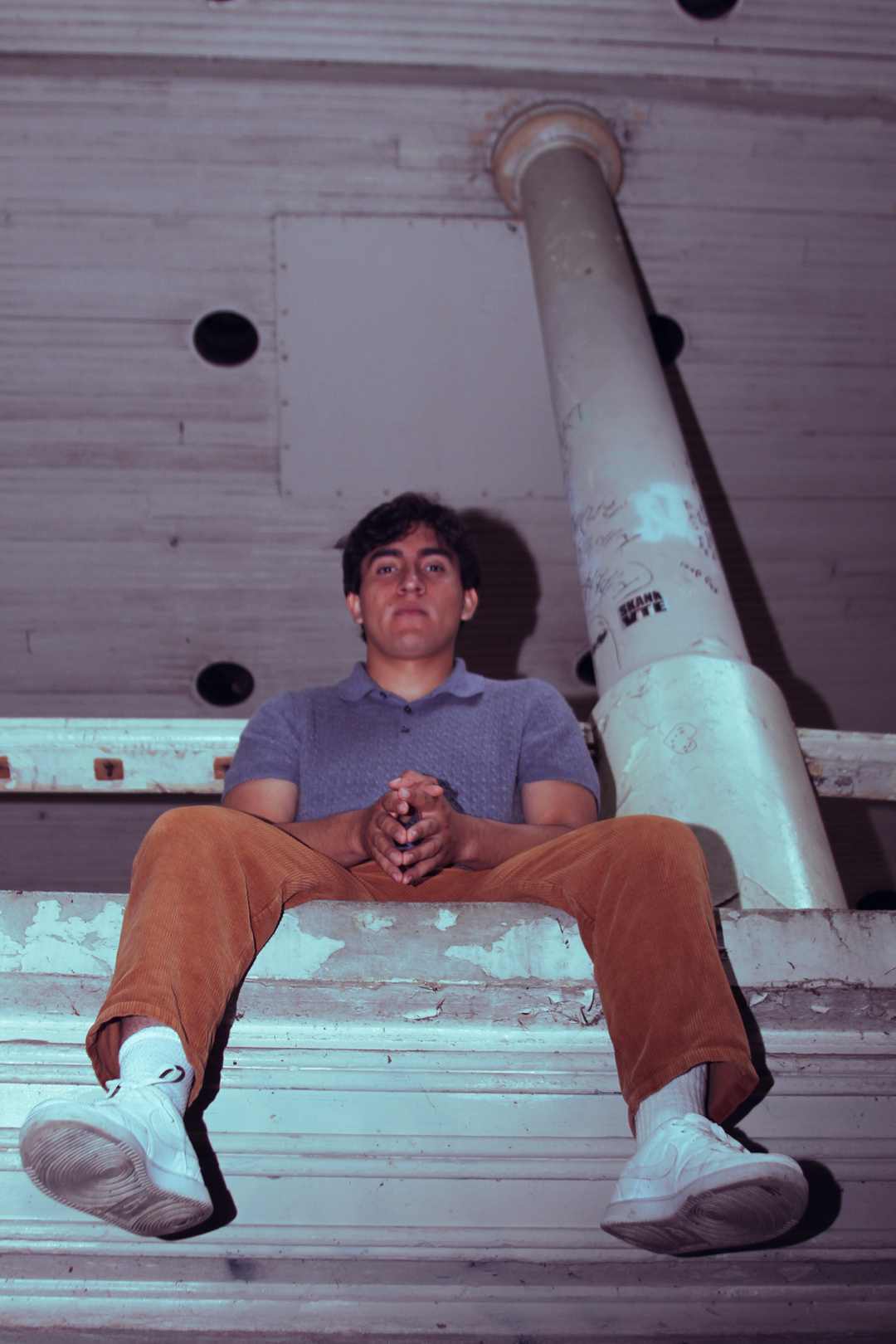 Chris Michael seated with a book looking out thoughtfully