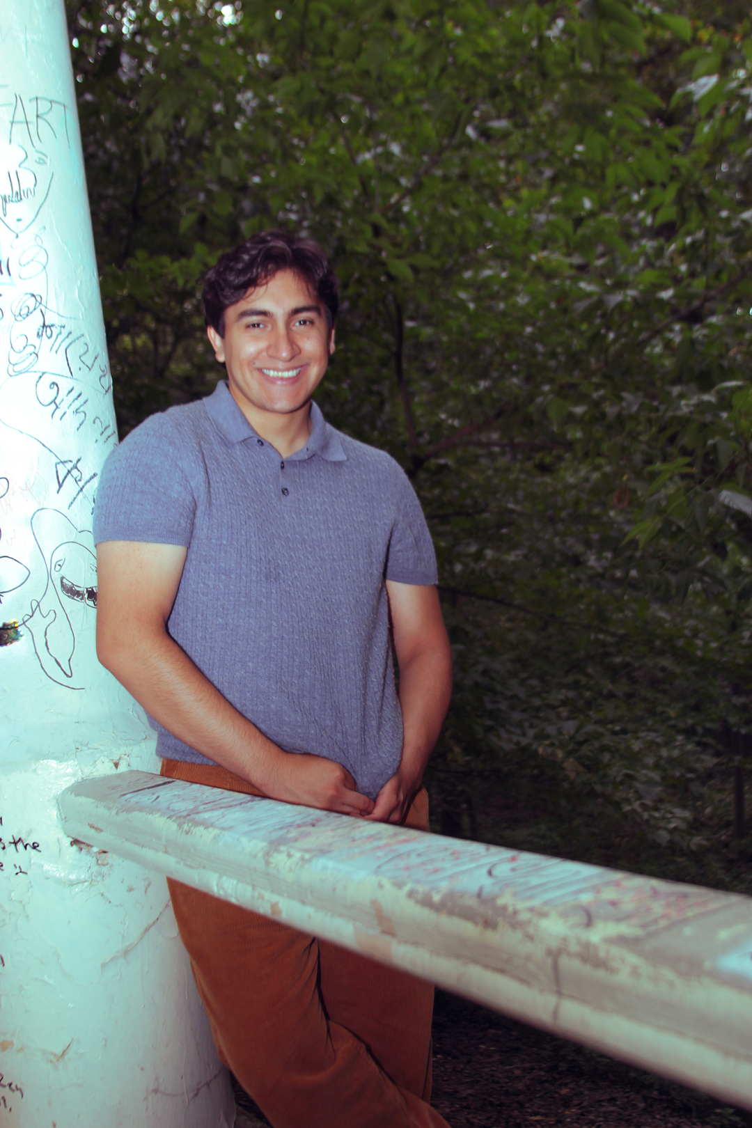 Chris Michael smiling by a graffiti-covered pillar